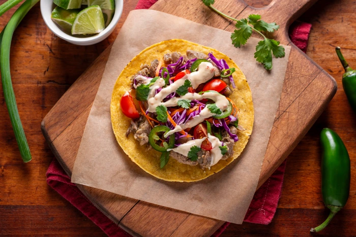 Corn tostada made with crispy corn tortilla topped with fresh vegetables, jalapeño and sauce