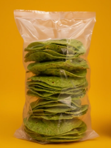 Green nopal tostadas stacked inside a clear plastic package