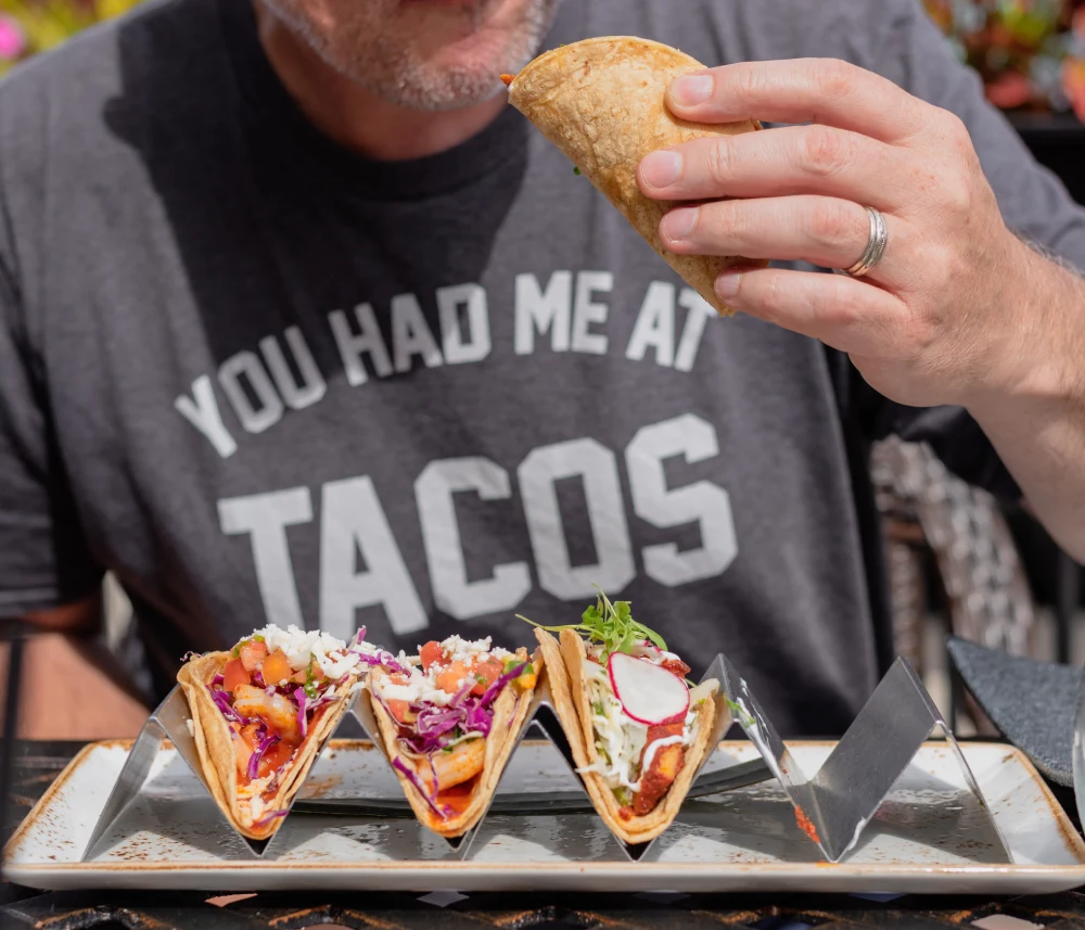 Customer enjoying tacos prepared with consistent tortilla quality representing reliable food product performance