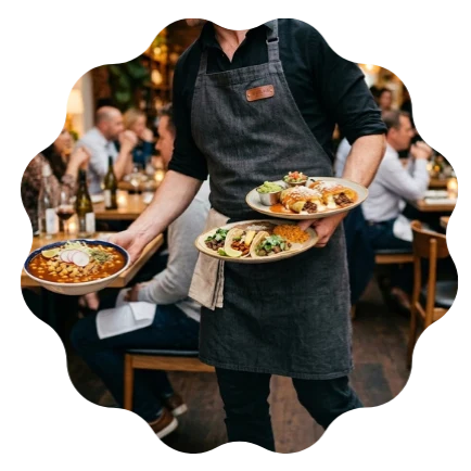 Restaurant server delivering prepared meals in a busy dining environment representing foodservice supply and restaurant operations
