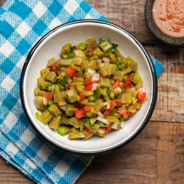Traditional nopal salad prepared with diced nopalitos, onions, tomatoes, and fresh ingredients